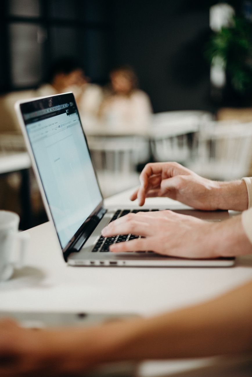 Journalist investigating information files on laptop in cafe